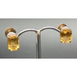 A pair of yellow metal screw back earrings each set with an emerald cut citrine stone. Unmarked
