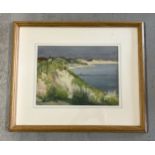 A framed and glazed watercolour of a beach and cliff top scene "The Dunes at Zoutelande" by Albert