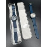 2 Swatch Watches. A 2003 #802 Swatch Watch with Blue silicone strap and brushed silver face, in