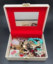 A large vintage cream coloured jewellery box and contents to include gold tone and beaded