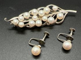 A vintage white metal and cultured pearl leaf shaped brooch with a pair of white metal single