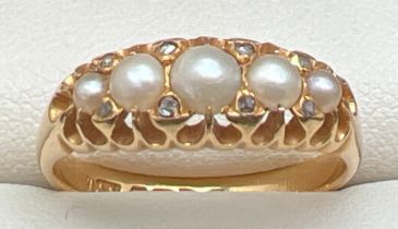 An antique Edwardian 18ct gold, pearl and diamond ring. Set with 5 graduated white pearls and 8