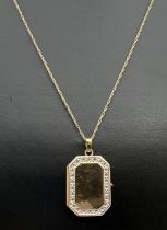 A rectangular shaped 9ct gold locket with small stone mount detail to edges (no stones). On an 18"