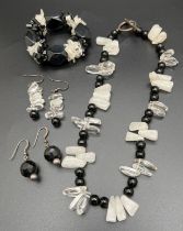 A modern design onyx, clear and opaque rock crystal necklace with silver T Bar clasp. Together