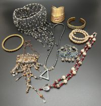 A collection of vintage costume jewellery. To include brass and copper cuff bangles, beaded choker