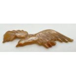 An Art Nouveau carved horn brooch modelled as a bird in flight, with pearlised finish. Approx. 9.5cm