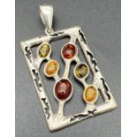 A large modern design square shaped pendant set with honey, green and cognac amber cabochons. With