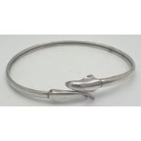 An adjustable silver bangle with dolphin detail. Marked Silver to inside. Approx. 7cm diameter.