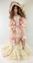 A large life sized soft bodied porcelain doll on a stand, in Victorian style dress with matching