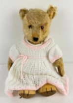A vintage jointed blonde mohair teddy bear. Glass eyes with hand stitched nose, mouth and claws.