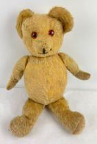 A vintage 16 inch jointed blonde teddy bear with growler. Glass eyes and hand stitched mouth. Wear