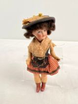 An antique 5 inch Unis of Paris French bisque head doll in a cotton dress and straw hat. Composite