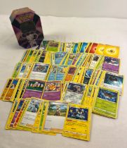 225 assorted Pokemon cards in a 2021 Pokemon V Forces Mew V octagonal shaped tin. Cards comprise 200