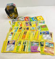 226 assorted Pokemon cards in a 2021 Pokemon Jolteon V octagonal shaped tin. Cards comprise 201