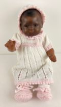 An antique 18 inch Black Dream baby doll by Armand Marseille with closing eyes and closed mouth.