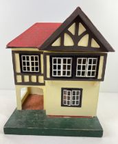 A small vintage Lines Bros Triang dolls house with car port, metal framed windows and a small