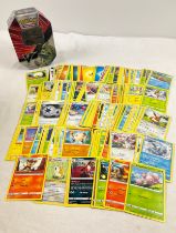 235 assorted Pokemon cards in a 2021 Pokemon V Tyranitar octagonal shaped tin. Cards comprise 187