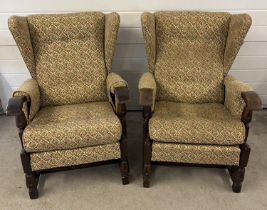 A pair of vintage 1930's dark oak framed wing back chairs with floral design upholstery and turned