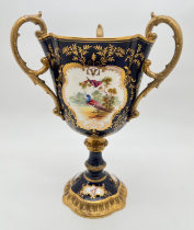 An antique Coalport ceramic 3 handled chalice in cobalt blue with gilt detail. Panelled design