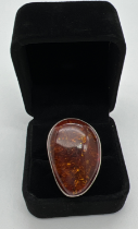 A very large cognac amber set silver dress ring. Stamped 925 to underside. Ring size PÂ½. Amber