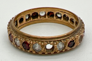 A vintage 9ct gold full eternity ring set with round cut garnets and clear stones (one garnet