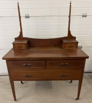 An Edwardian satin wood dressing table with inlaid detail and tapered legs, raised on ceramic caster