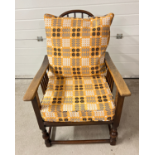 A vintage Arts & Crafts style recliner dark wood chair with curved spindle back. With re upholstered