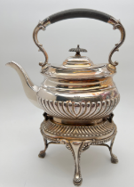 An Edwardian silver plated spirit kettle of reeded design, on hinged stand raised on 4 padded