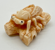 A carved netsuke modelled as an insect on a branch, with engraved signature to underside. No