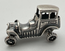 A small 925 silver model of a vintage veteran car with moving wheels. Stamped 925 to underside.