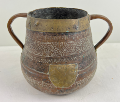 A decorative hammered copper & brass Tibetan 2 handled pot. Approx. 22cm tall x 20cm diameter.
