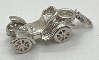 A small silver model/charm of a classic car with lobster style clasp and moving wheels. Silver