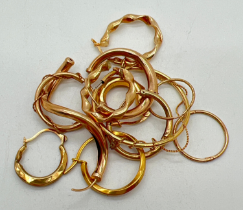 A small quantity of scrap gold earrings, mostly hoop style. All test or marked as 9ct gold. Total