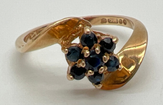 A 9ct gold flower design sapphire set dress ring in a twist design mount. Central small round cut