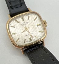 A ladies vintage 9ct gold case wristwatch with black leather strap by Rotary. Gold tone hour markers