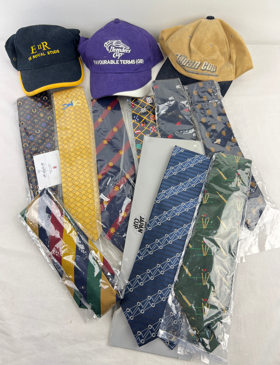 A collection of Horse Racing ties and caps. Ties all as new, mostly in cellophane packaging, to