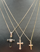 3 silver necklaces each with a small cross pendant. A plain cross on a fine belcher chain, a cross