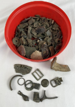 A tub of metal detector finds. To include buckles, coins and cow parts of cow bells.