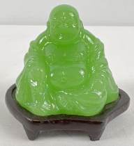 A small carved green jade sitting Buddha figure on a small wooden stand. Figure approx. 5.5cm tall.