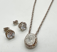 A silver oval cut rock crystal pendant surrounded by small clear stones on a 18 inch rope chain