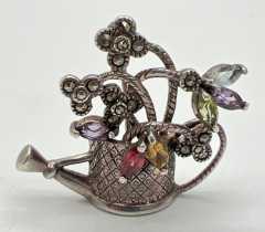 A vintage silver brooch modelled as a watering can, set with marquis cut gemstones and marcasite'