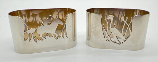 2 vintage silver Garrard & Co novelty napkin rings with cut out details of country scenes. A heron -