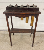 A vintage 1920's brass and dark oak marimbaphone/glockenspiel raised on slim square legs with curved