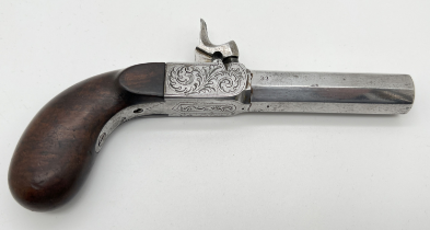 An antique percussion pocket pistol with wooden grip and engraved hardware. Barrel stamped 33,