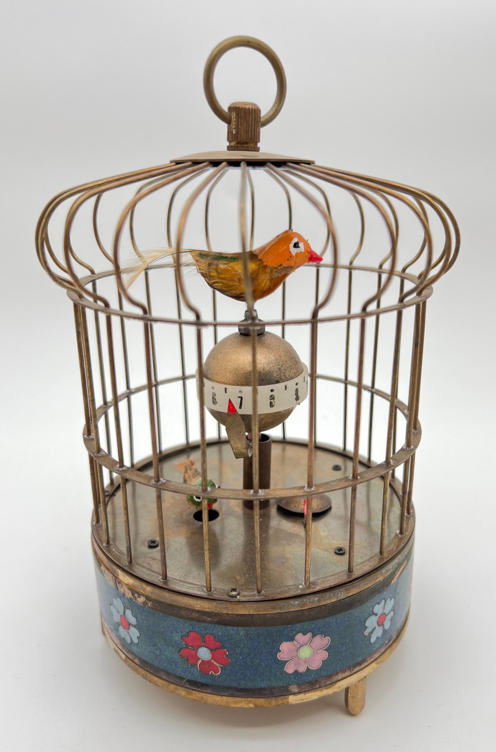 A brass ornamental wind up birdcage clock with winding mechanism to underside and blue cloisonne