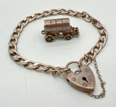 A vintage silver curb chain charms bracelet with padlock and safety chain together with a white