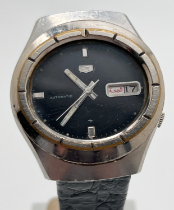 A vintage Seiko 5 023159 automatic wristwatch with black leather strap. With Arabic day and date