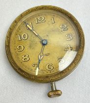 A vintage circular 8 day travelling clock without carry case. Pale gold face and hour markers, Greek