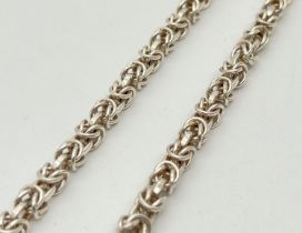 A heavy silver 18" Byzantine chain with lobster claw clasp. Silver marks to clasp and fixings. Total