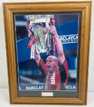 A framed and glazed signed photo of Rio Ferdinand, "nice One" written above signature. Complete with